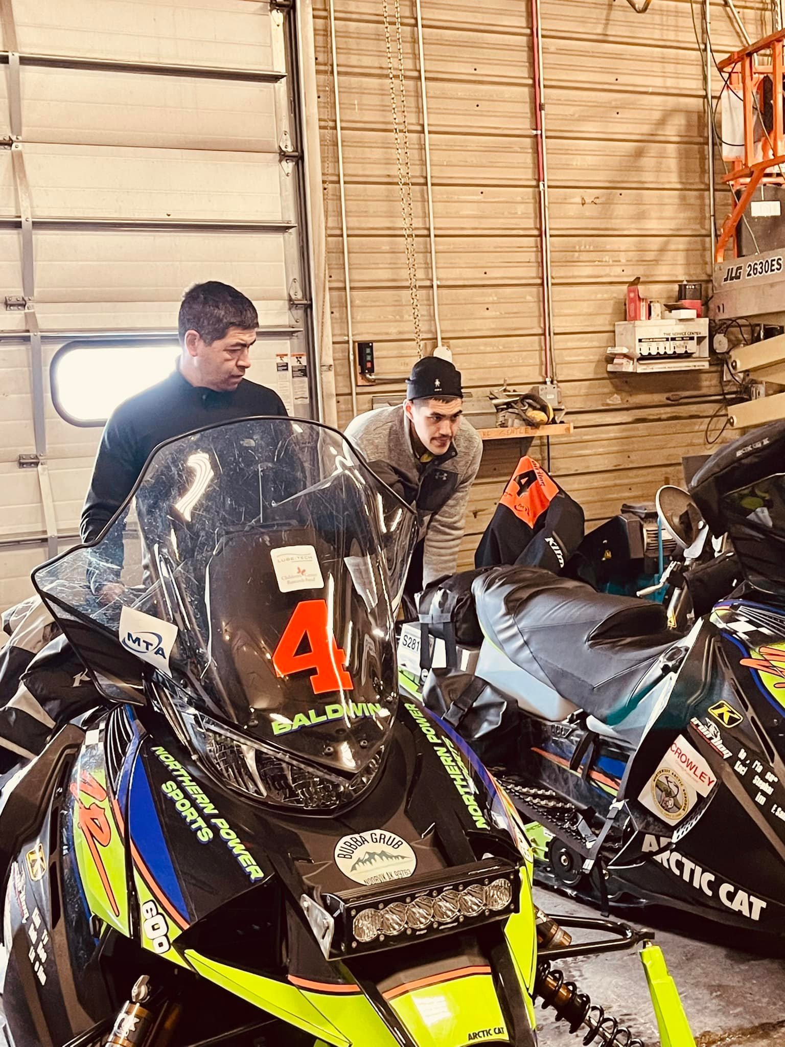 Team 4, Jim Baldwin from Kiana, left, and Steven Williamson from Noorvik, work on their sleds in the garage in Nome. Courtesy Penny Olanna