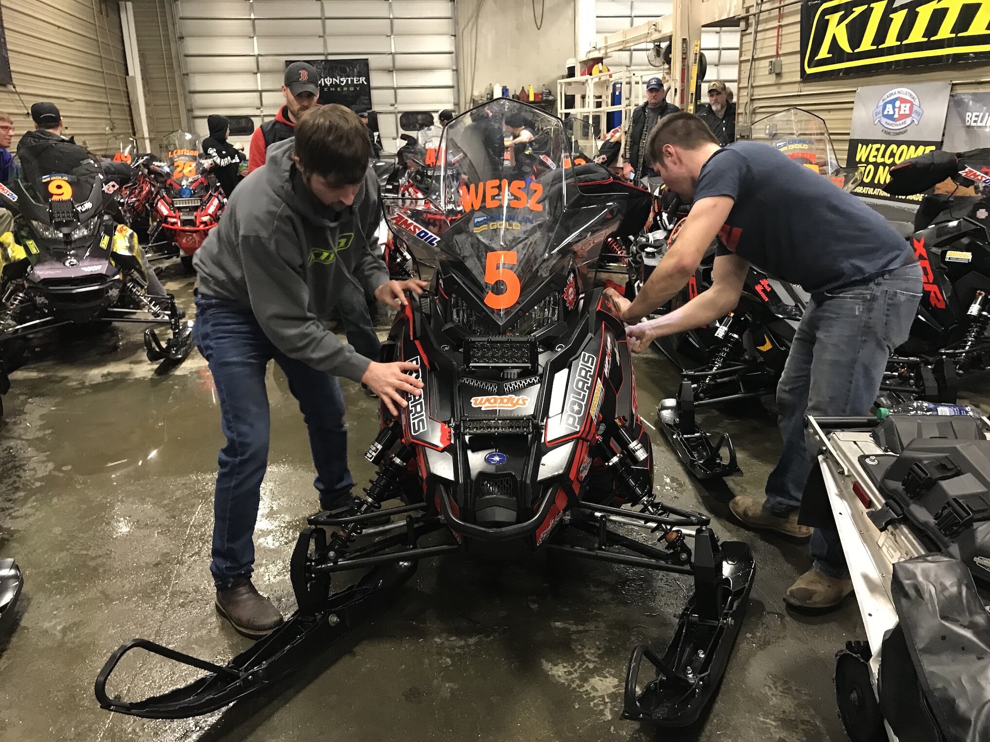 Aaron Brown Team 5, Andy Gocke and Zack Weisz, wrench in the garage in Nome during the 2018 Iron Dog.