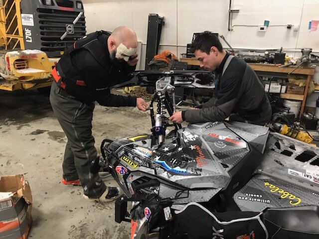 Robert and Forest Strick worked on one of their sleds in the garage in Kiana before heading out. They soon would return, and scratch, from Iron Dog 37.